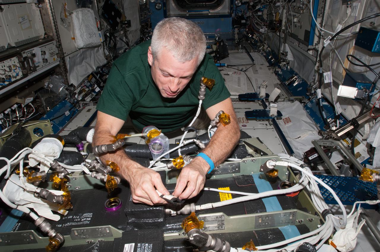 ISS039-E-010367 (9 April 2014) --- In the Kibo laboratory aboard the International Space Station, Expedition 39 Flight Engineer Steve Swanson works during in-flight maintenance to mate electrical connectors in Tranquility's Carbon Dioxide Removal Assembly (CDRA). The image was taken during the second day of CDRA in-flight maintenance.