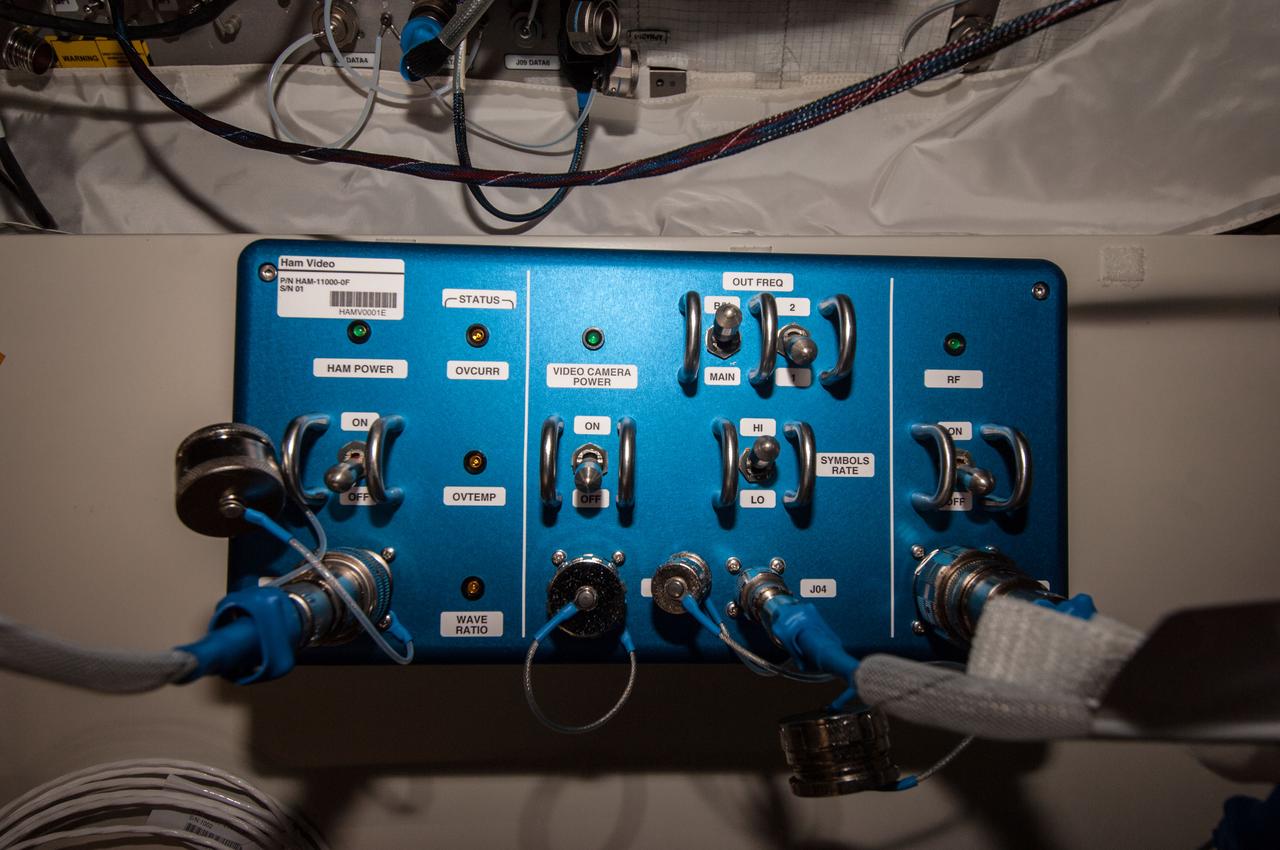 Documentation of the Ham Video unit installed in the Columbus European Laboratory. Part number (P/N) is HAM-11000-0F, serial number (S/N) is 01, barcode is HAMV0001E. Image was taken during Expedition 39 Ham Video commissioning activities and released by astronaut on Twitter.