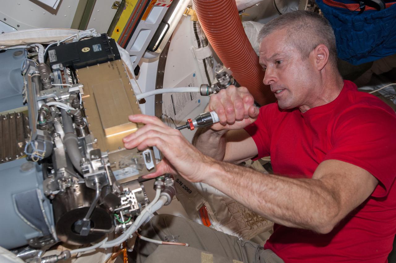 ISS039-E-011886 (14 April 2014) --- In the Quest airlock of the International Space Station, Expedition 39 Flight Engineer Steve Swanson of NASA works on one of the Extravehicular Mobility Unit (EMU) spacesuits to be used on an upcoming spacewalk on which Swanson and crewmate Rick Mastracchio of NASA will participate.