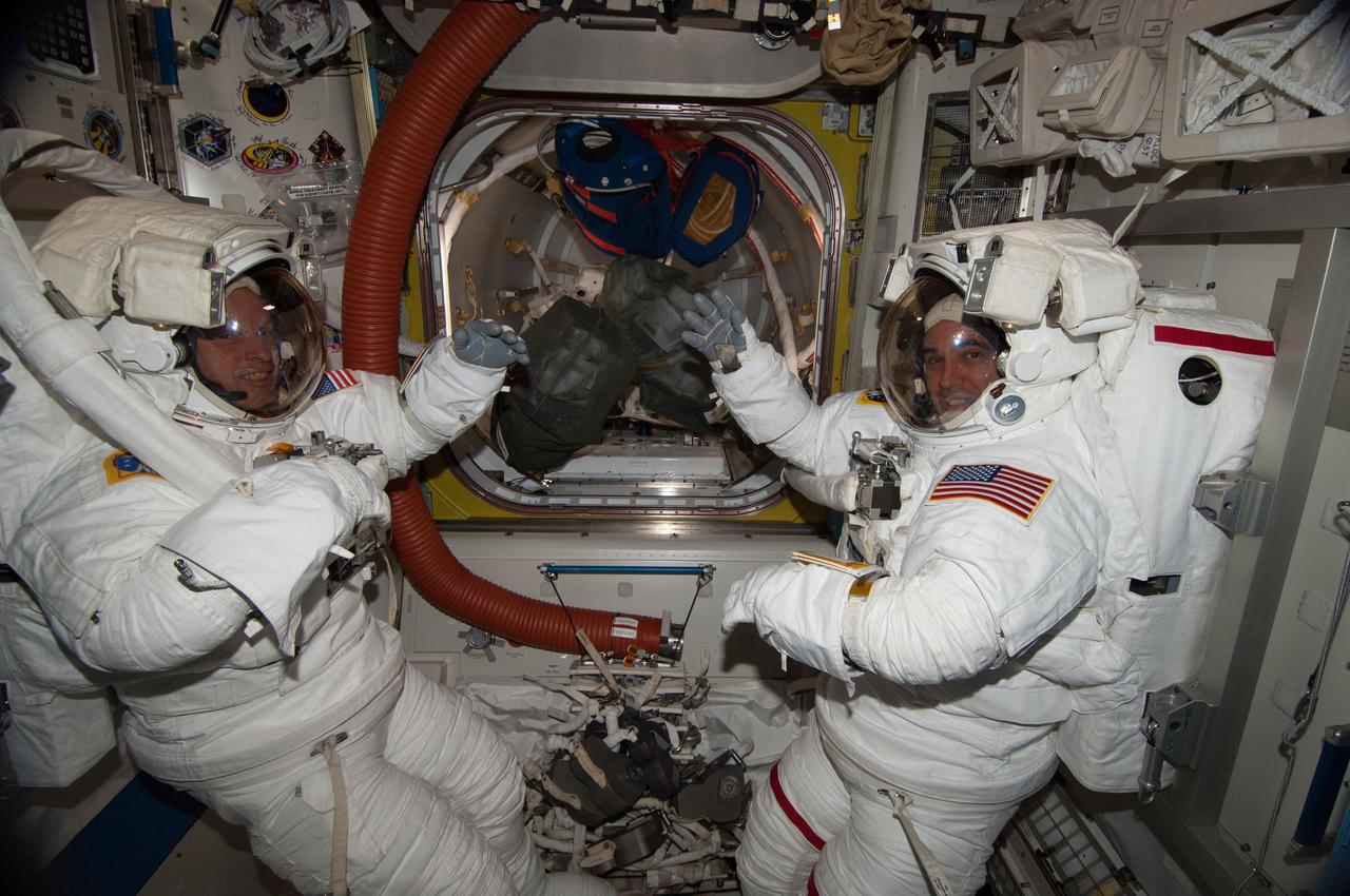 ISS039-E-013152 (17 April 2014) --- Inside the Quest airlock of the International Space Station, NASA astronauts Steve Swanson (left) and Rick Mastracchio, both Expedition 39 flight engineers, participate in a dress rehearsal for an upcoming spacewalk during which they are to replace a failed backup computer relay box in the S0 truss.