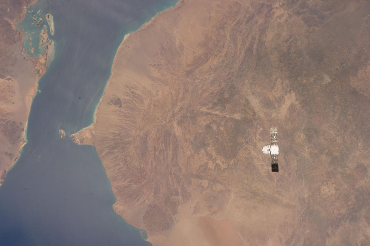 ISS039-E-013569 (20 April 2014) --- This is one of an extensive series of still photos documenting the April 20 arrival and ultimate capture and berthing of the SpaceX Dragon at the International Space Station, as photographed by the Expedition 39 crew members onboard the orbital outpost. In this photo, the two orbiting spacecraft were above a point in Yemen. Part of the Gulf of Aden and the Red Sea, can be seen at left. The Dragon spacecraft was captured by the space station and successfully berthed using the Canadian-built space station remote manipulator system or Canadarm2.