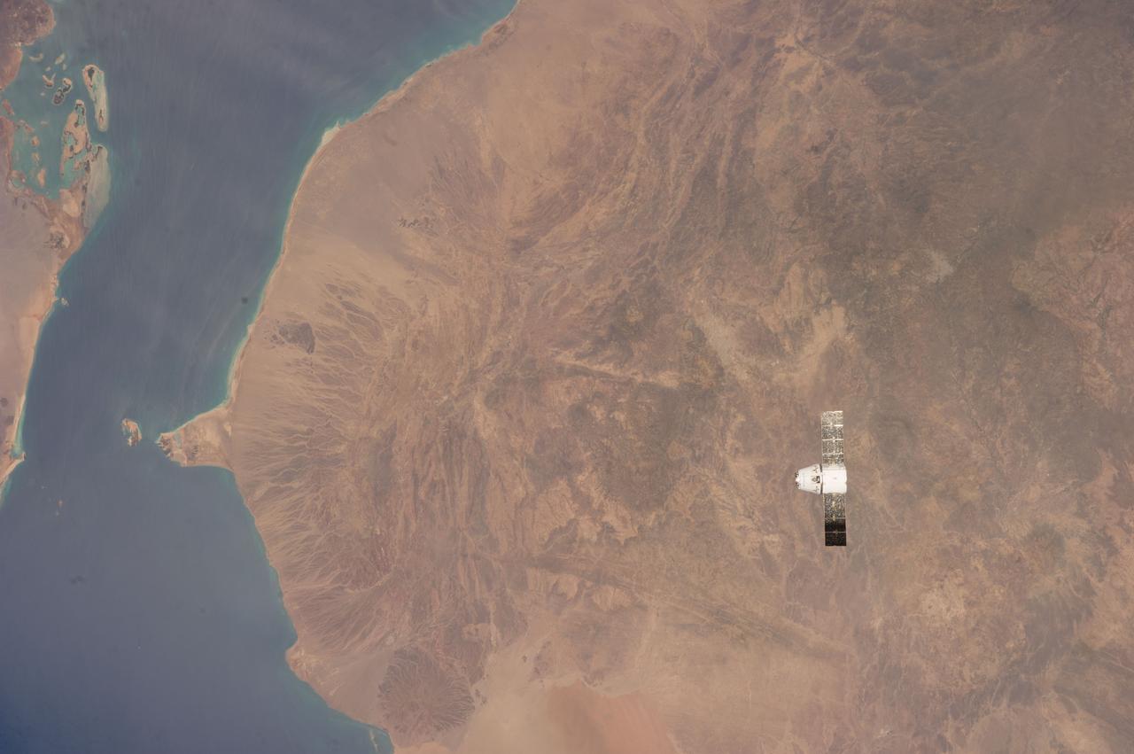 ISS039-E-013570 (20 April 2014) --- This is one of an extensive series of still photos documenting the April 20 arrival and ultimate capture and berthing of the SpaceX Dragon at the International Space Station, as photographed by the Expedition 39 crew members onboard the orbital outpost. In this photo, the two orbiting spacecraft were above a point in Yemen. Part of the Gulf of Aden and the Red Sea, can be seen at left. The Dragon spacecraft was captured by the space station and successfully berthed using the Canadian-built space station remote manipulator system or Canadarm2.