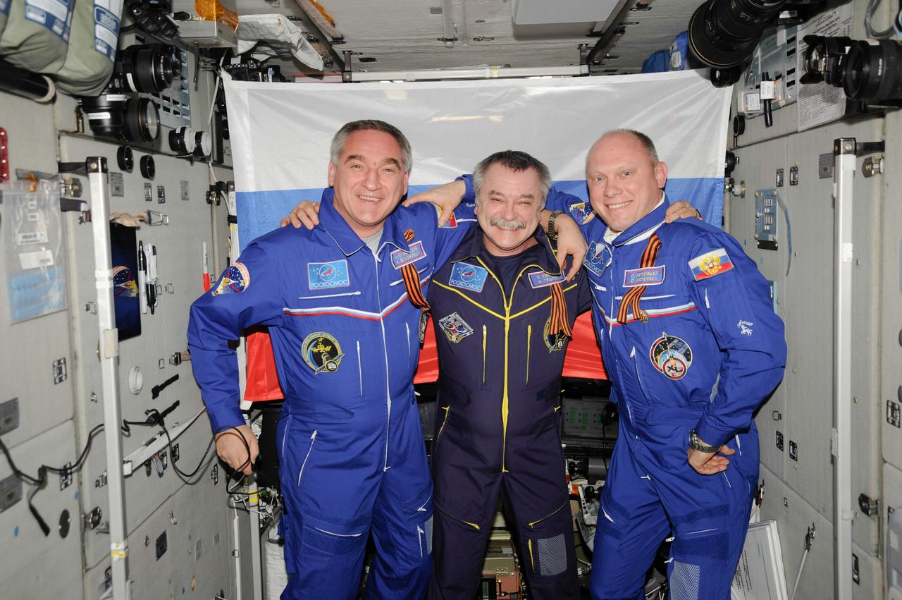 ISS039-E-014259 (22 April 2014) --- Inside the Zvezda service module on the Earth-orbiting International Space Station, three cosmonauts representing Russia's Federal Space Agency (Roscosmos) gather for a televised event. From the left are Flight Engineers Alexander Skvortsov, Mikhail Tyurin and Oleg Artemyev.