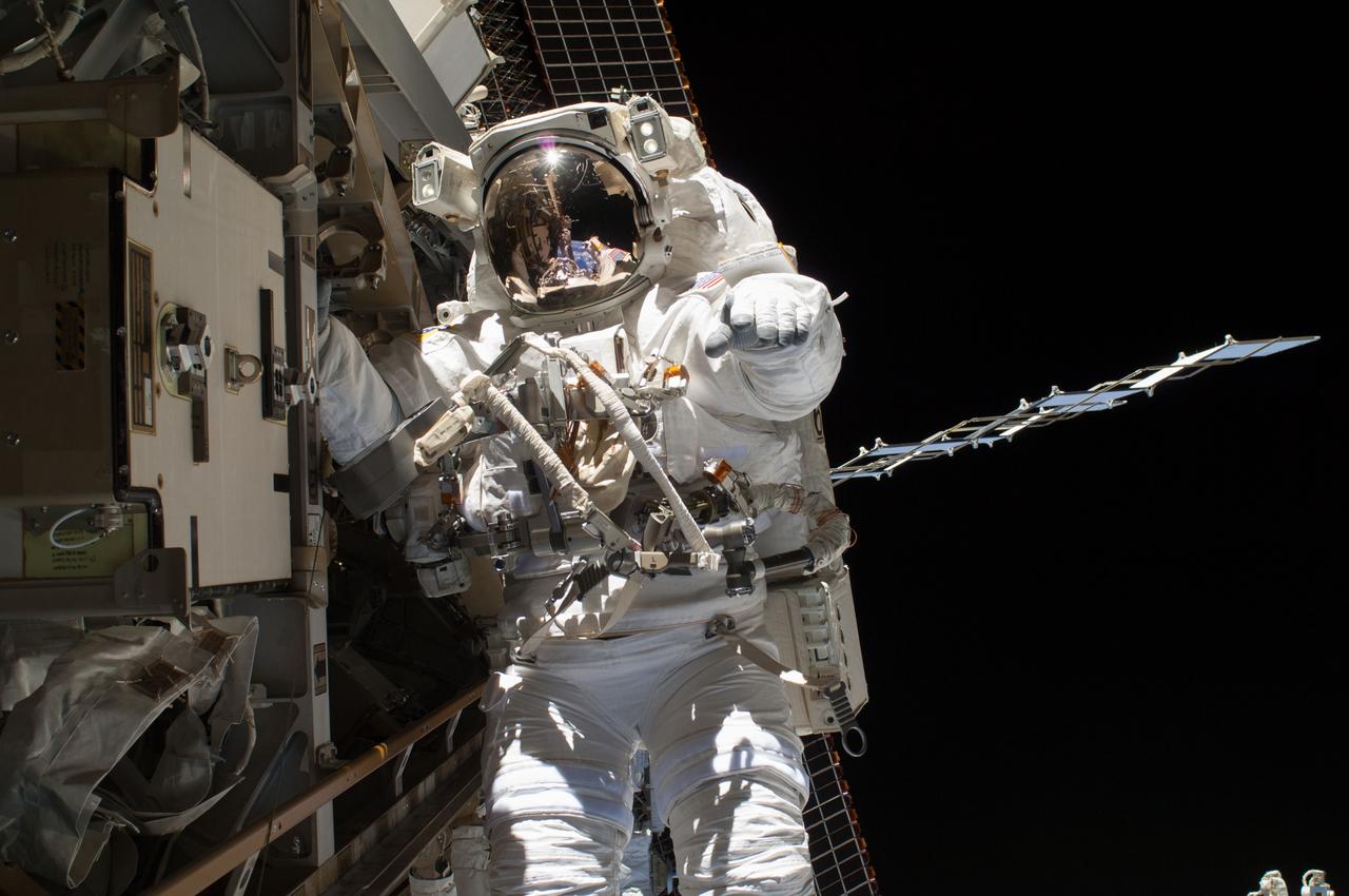 ISS039-E-014893 (22 April 2014) --- NASA astronaut Steve Swanson is pictured during a spacewalk to replace a failed backup computer relay box in the S0 truss of the International Space Station on April 22, 2014.  He was accompanied on the spacewalk by fellow Flight Engineer Rick Mastracchio of NASA, who can be seen as a tiny figure anchored several yards away reflected in Swanson's helmet visor.