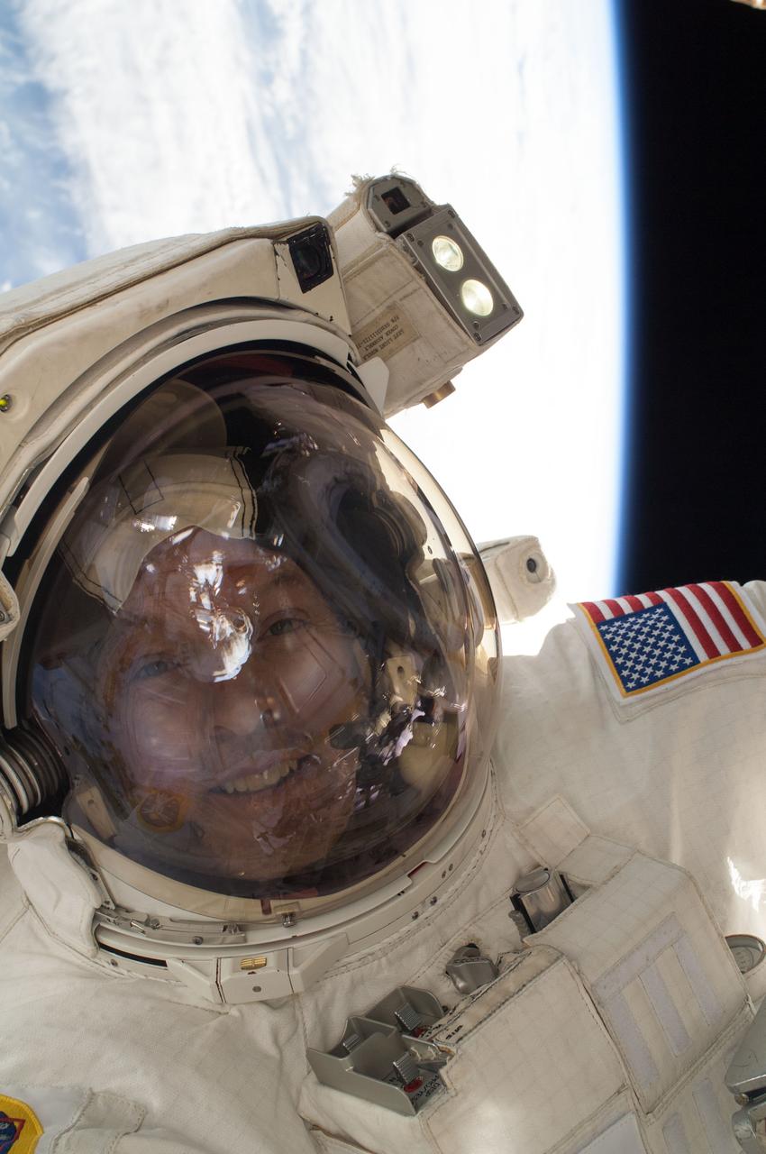 Close-up view of Expedition 39 flight engineer Steve Swanson backdropped by Earth and space at the end of Extravehicular Activity 26 (EVA 26).