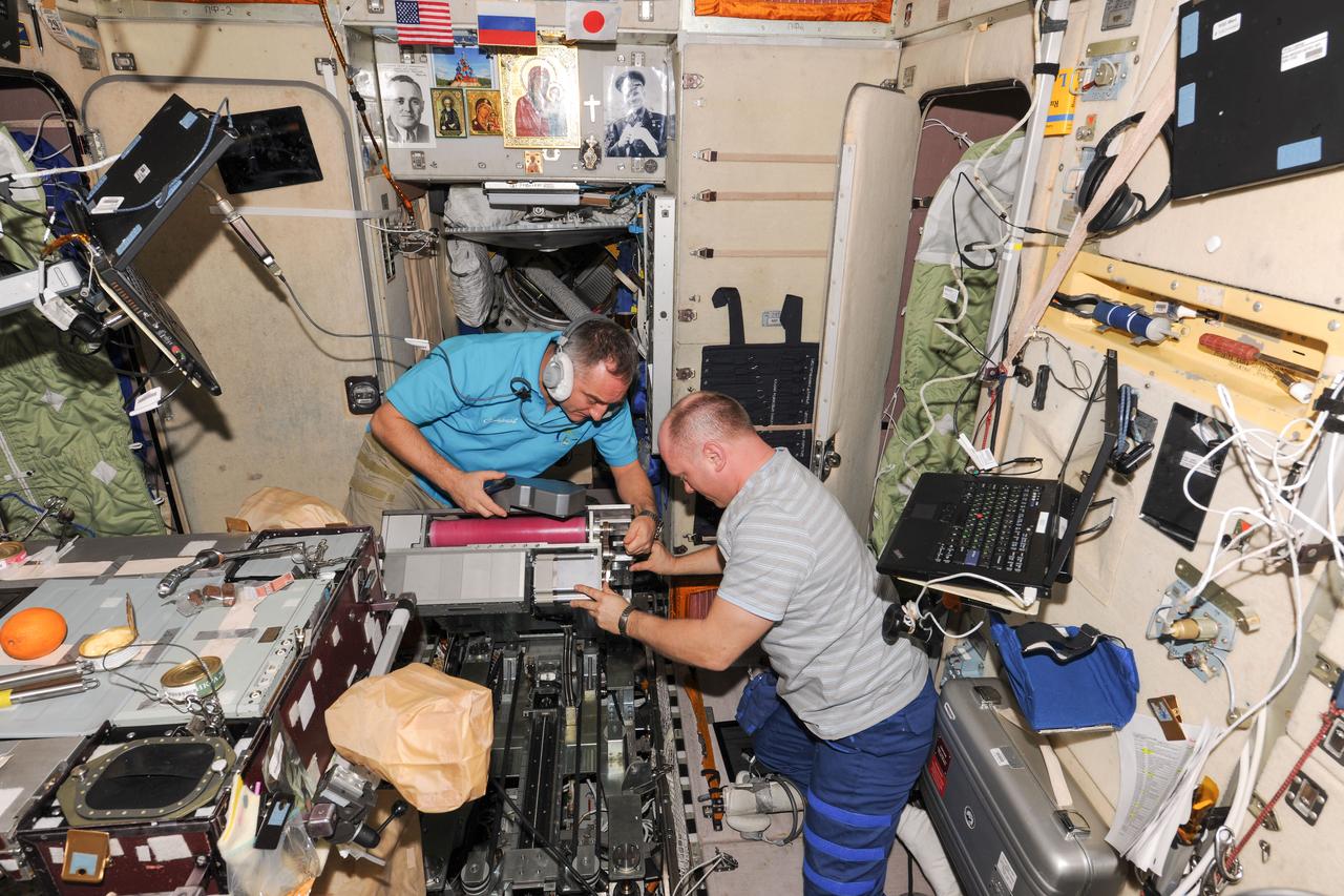 ISS039-E-016480 (30 April 2014) --- Russian cosmonauts Oleg Artemyev (right) and Alexander Skvortsov with Russia's Federal Space Agency (Roscosmos) work on the BD-2 treadmill in the Zvezda service module aboard the Earth-orbiting International Space Station.