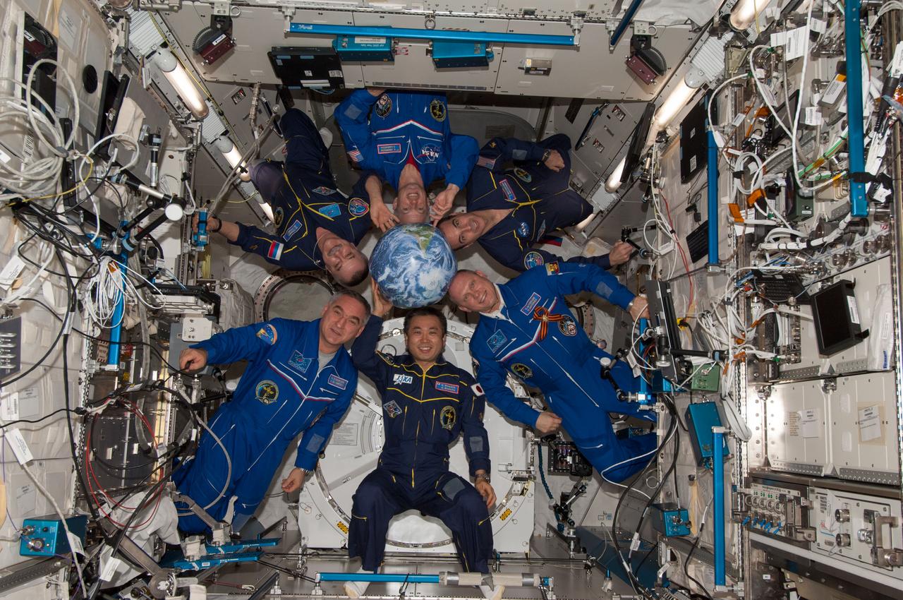 ISS039-E-017656 (3 May 2014) --- The phrase "encircling the Earth" has a double entendre flavor to it in this picture showing all six Expedition 39 crew members in the Kibo module around a globe while actually orbiting the "real thing" aboard the International Space Station. Expedition 39 Commander Koichi Wakata of the Japan Aerospace Exploration Agency (JAXA) is at bottom center. Clockwise from his position are Flight Engineers Alexander Skvortsov and Mikhail Tyurin of Russia's Federal Space Agency (Roscosmos), Steve Swanson and Rick Mastracchio of NASA and Oleg Artemyev of Roscosmos.