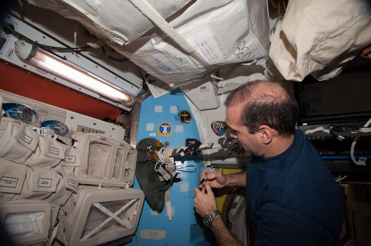 ISS039-E-020704 (13 May 2014) --- NASA astronaut Rick Mastracchio, Expedition 39 flight engineer, signs a wall in the Quest airlock of the Earth-orbiting International Space Station after mounting his crew patch, continuing a Quest-based tradition of station crew members who have participated in space walks on their respective flights. A short time later, Mastracchio joined Expedition 39 Commander Koichi Wakata of the Japan Aerospace Exploration Agency and Flight Engineer Mikhail Tyurin of Roscosmos as they departed the orbital outpost in a Soyuz vehicle.