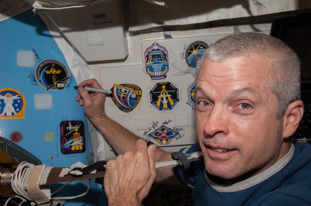 NASA image: Swanson signs Mission Patch in A/L