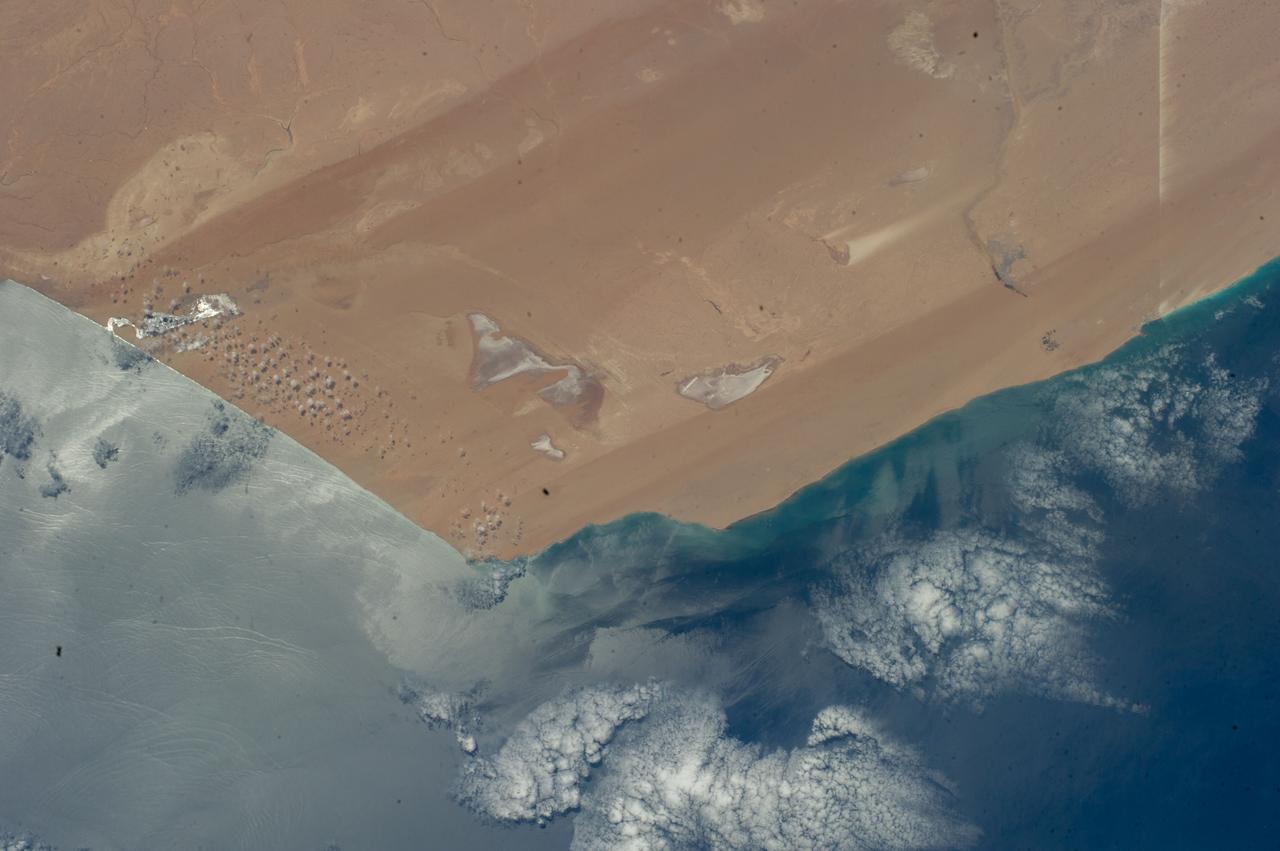 ISS040-E-000788 (20 May 2014) --- Expedition 40 Commander Steve Swanson of NASA photographed this image from an Earth-facing window on the Earth-orbiting International Space Station featuring the Atlantic coast of the African nation of Morocco and the disputed territory of Western Sahara on May 20, 2014. The town of Tarfaya, Morocco, located at 22.45 degrees north latitude, and 13.13 degrees, east longitude, is visible. Obvious streaks in the sand were created by northerly winds.