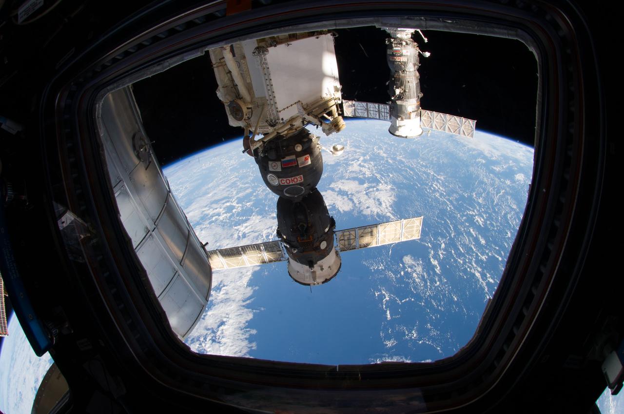 ISS040-E-006183 (1 June 2014) --- The Permanent Multipurpose Module (PMM), the Soyuz 39 (TMA-13M) spacecraft (center) docked to the Rassvet Mini-Research Module 1 (MRM1) and the Progress 55 resupply vehicle (background) docked to the Pirs Docking Compartment are featured in this image photographed by an Expedition 40 crew member from a window in the Cupola of the International Space Station. A blue and white part of Earth provides the backdrop for the scene.
