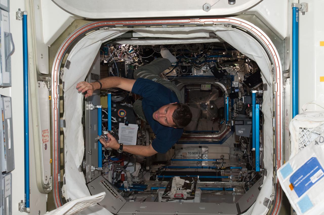 ISS040-E-006564 (30 May 2014) --- NASA astronaut Reid Wiseman, Expedition 40 flight engineer, floats through the hatch between the Destiny laboratory and the Unity node of the International Space Station.