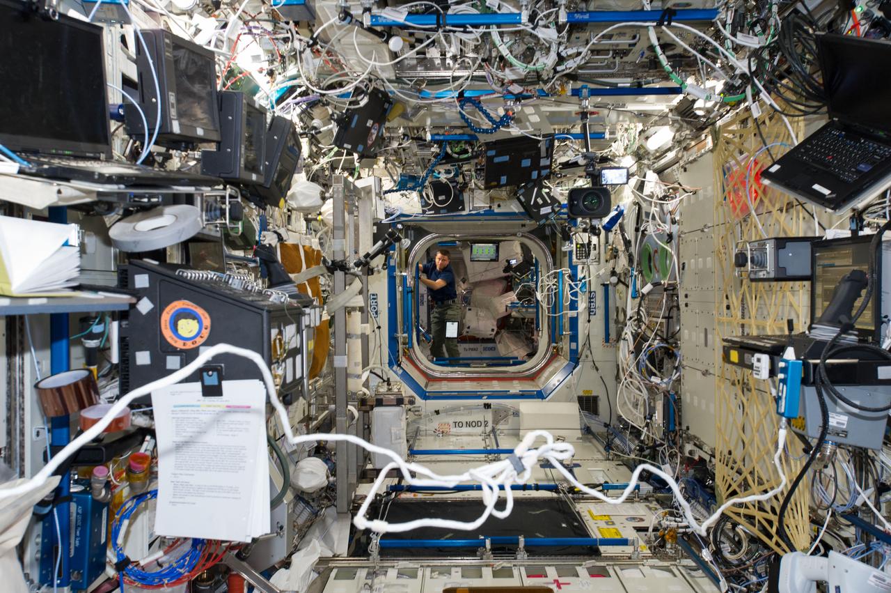 ISS040-E-006890 (3 June 2014) --- Photographed from the Destiny laboratory, NASA astronaut Reid Wiseman, Expedition 40 flight engineer, is pictured in the Harmony node of the International Space Station.