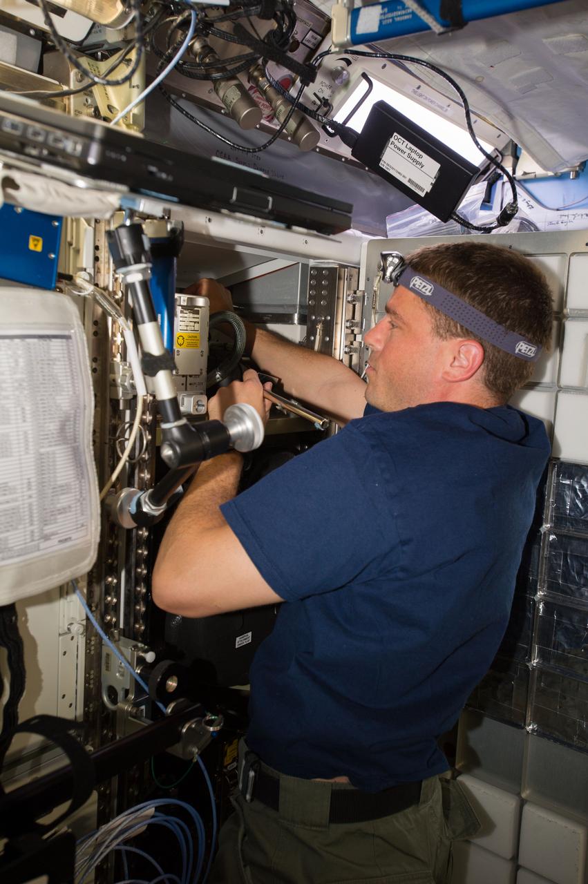ISS040-E-007122 (4 June 2014) --- NASA astronaut Reid Wiseman, Expedition 40 flight engineer, works with the Common Cabin Air Assembly (CCAA) in the Destiny laboratory of the International Space Station.