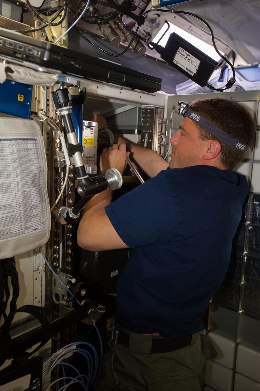ISS040-E-007123 (4 June 2014) --- NASA astronaut Reid Wiseman, Expedition 40 flight engineer, works with the Common Cabin Air Assembly (CCAA) in the Destiny laboratory of the International Space Station.
