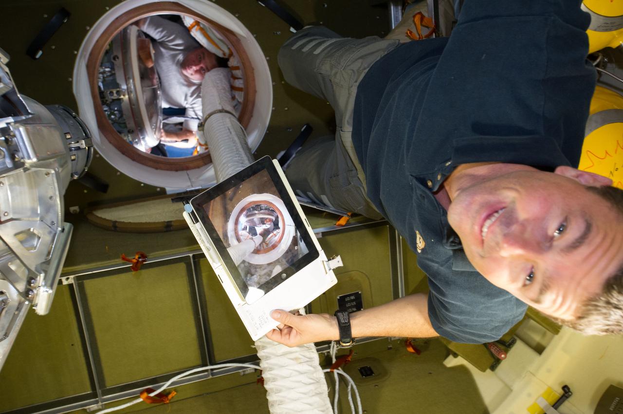 ISS040-E-008030 (6 June 2014) --- NASA astronaut Reid Wiseman and Russian cosmonaut Maxim Suraev (background), both Expedition 40 flight engineers, are pictured in the Russian segment of the International Space Station.