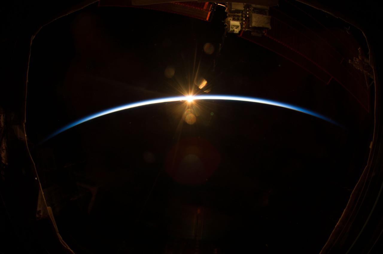 ISS040-E-008169 (7 June 2014) --- The sun, peeking through the thin line of Earth’s atmosphere, is featured in this image photographed by an Expedition 40 crew member on the International Space Station. Crew members onboard the space station see, on average, sixteen sunrises and sunsets during a 24-hour orbital period.