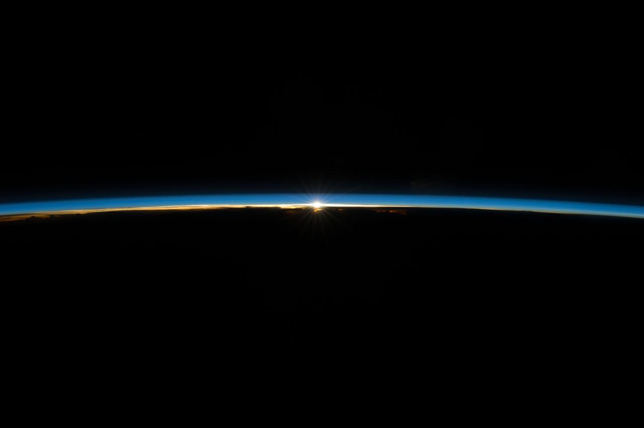 ISS040-E-008179 (7 June 2014) --- The sun, peeking through the thin line of Earth’s atmosphere, is featured in this image photographed by an Expedition 40 crew member on the International Space Station. Crew members onboard the space station see, on average, sixteen sunrises and sunsets during a 24-hour orbital period.