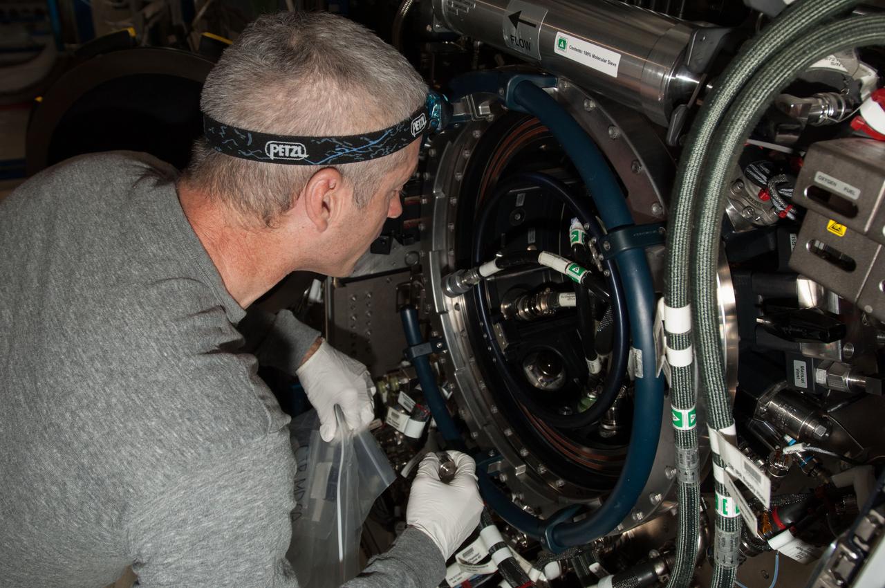 ISS040-E-010496 (11 June 2014) --- NASA astronaut Steve Swanson, Expedition 40 commander, works with the Multi-user Drop Combustion Apparatus (MDCA) inside the Combustion Integrated Rack (CIR) in the Destiny laboratory of the International Space Station. The MDCA contains hardware and software to conduct unique droplet combustion experiments in space.