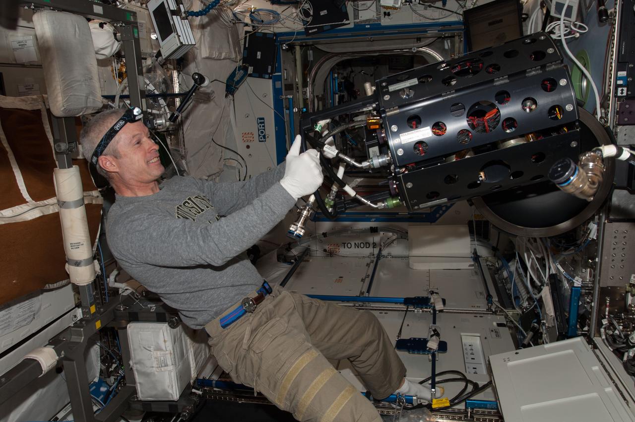 ISS040-E-010502 (11 June 2014) --- NASA astronaut Steve Swanson, Expedition 40 commander, works with the Multi-user Drop Combustion Apparatus (MDCA) inside the Combustion Integrated Rack (CIR) in the Destiny laboratory of the International Space Station. The MDCA contains hardware and software to conduct unique droplet combustion experiments in space.
