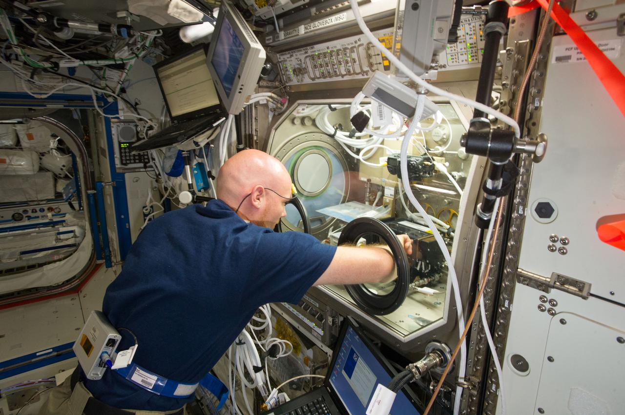 ISS040-E-011004 (13 June 2014) --- European Space Agency astronaut Alexander Gerst, Expedition 40 flight engineer, works with samples and hardware for a combustion experiment known as the Burning and Suppression of Solids (BASS) in the Microgravity Science Glovebox (MSG) in the Destiny laboratory of the International Space Station.