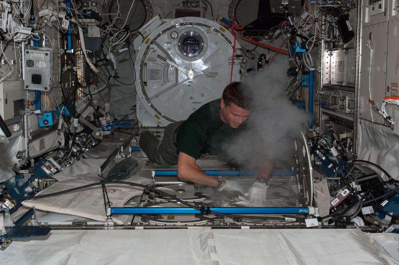 View of Astronaut Reid Wiseman,Expedition 40 flight engineer,inserting urine samples in the Minus Eighty Laboratory Freezer for ISS (MELFI) located in the Japanese Experiment Module (JEM).