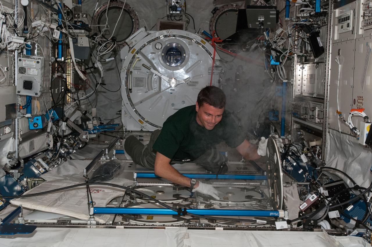 View of Astronaut Reid Wiseman,Expedition 40 flight engineer,inserting urine samples in the Minus Eighty Laboratory Freezer for ISS (MELFI) located in the Japanese Experiment Module (JEM).