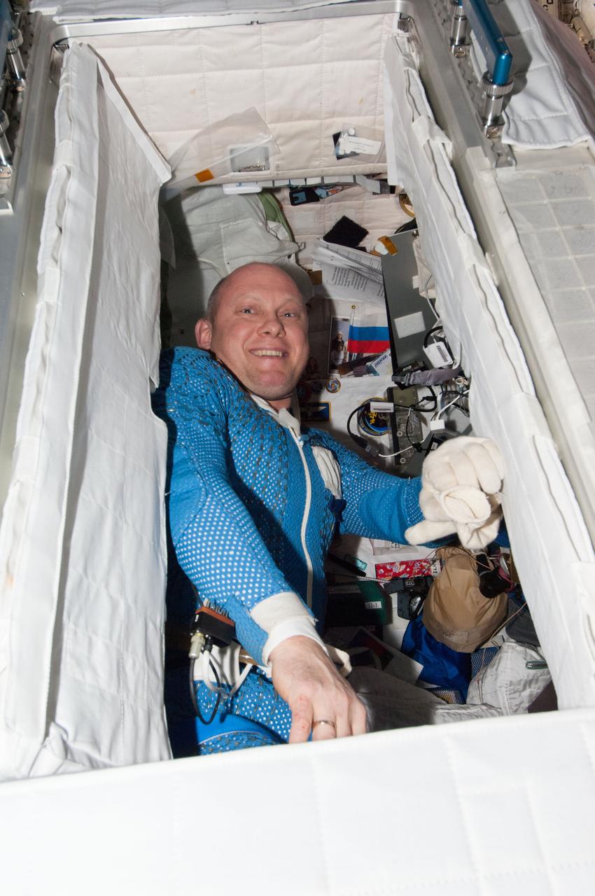 Cosmonaut Oleg Artemyev, Expedition 40 flight engineer, is photographed still wearing his liquid cooling and ventilation garment after a Russian Extravehicular Activity (EVA). Artemyev is standing in his crew quarters (CQ).