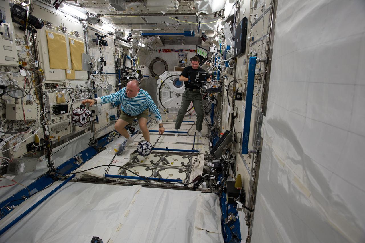ISS040-E-018466 (24 June 2014) --- Russian cosmonaut Oleg Artemyev (left) and NASA astronaut Reid Wiseman, both Expedition 40 flight engineers, conduct a session of the Synchronized Position Hold, Engage, Reorient, Experimental Satellites Zero Robotics (SPHERES ZR) program in the Kibo laboratory of the International Space Station.