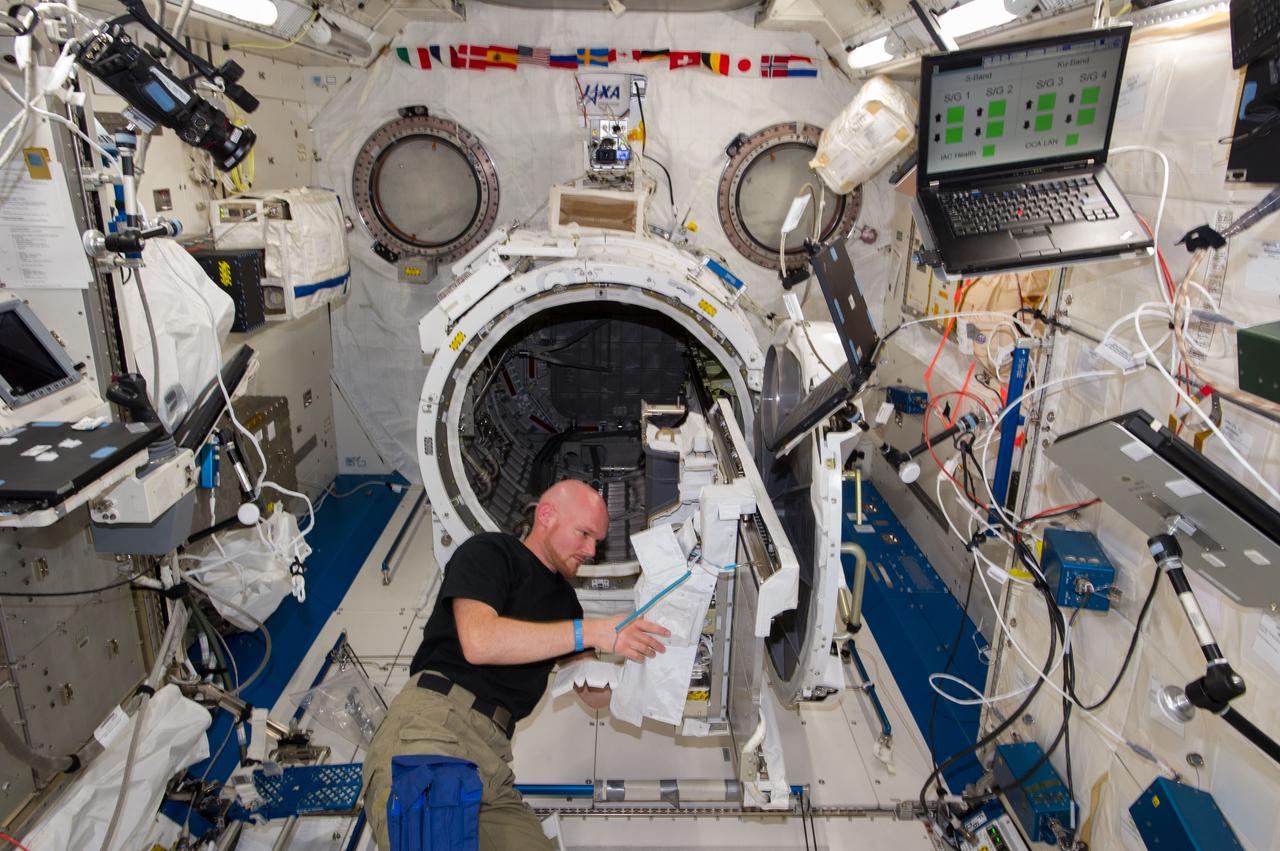 ISS040-E-019318 (25 June 2014) --- In the International Space Station?s Kibo laboratory, European Space Agency astronaut Alexander Gerst, Expedition 40 flight engineer, prepares to transfer a multi-purpose experiment platform and a robotic arm known as the Small Fine Arm through the Kibo module?s scientific airlock. The Small Fine Arm, which attaches to the Kibo?s larger main arm, handles delicate operations involved in exchanging experiments and payloads located on the Exposed Facility.