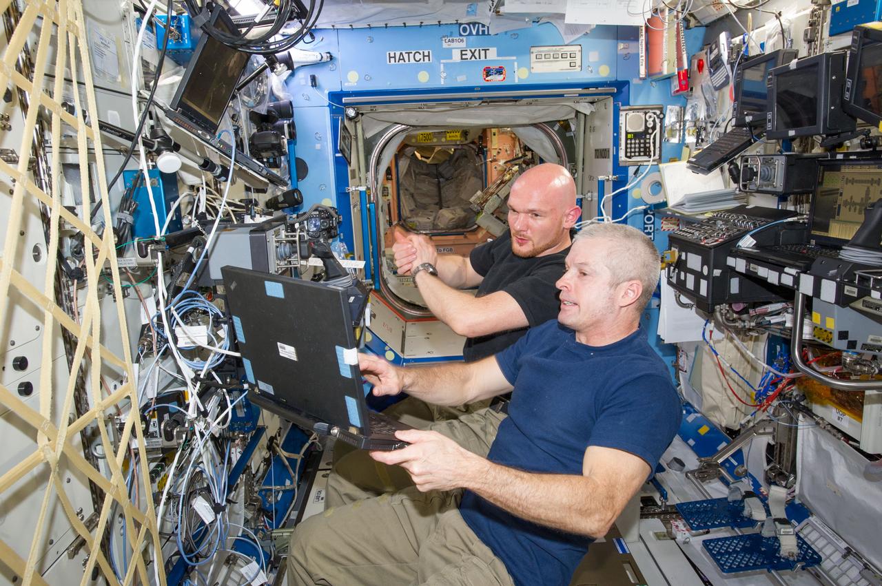 ISS040-E-020345 (25 June 2014) --- In the International Space Station?s Destiny laboratory, NASA astronaut Steve Swanson (foreground), Expedition 40 commander; and European Space Agency astronaut Alexander Gerst, flight engineer, participate in a training session for the robotic capture of the Orbital Sciences? Cygnus cargo craft, set to launch on the Orbital-2 commercial resupply services flight no earlier than July 10.
