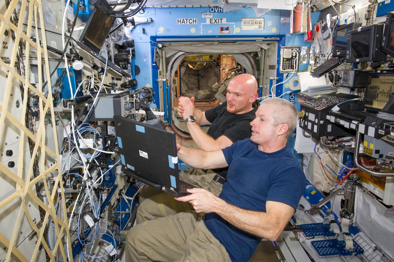 ISS040-E-020346 (25 June 2014) --- In the International Space Station?s Destiny laboratory, NASA astronaut Steve Swanson (foreground), Expedition 40 commander; and European Space Agency astronaut Alexander Gerst, flight engineer, participate in a training session for the robotic capture of the Orbital Sciences? Cygnus cargo craft, set to launch on the Orbital-2 commercial resupply services flight no earlier than July 10.