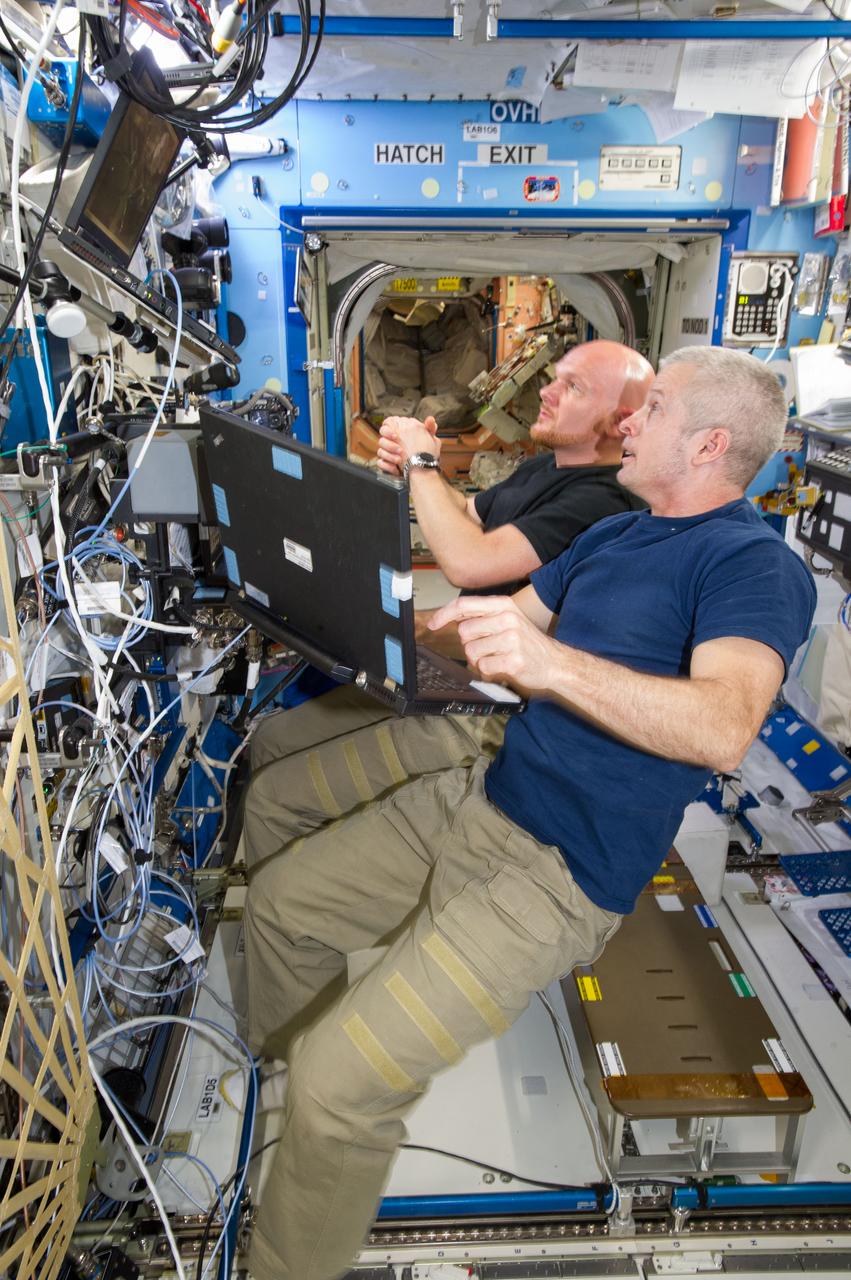 ISS040-E-020349 (25 June 2014) --- In the International Space Station?s Destiny laboratory, NASA astronaut Steve Swanson (foreground), Expedition 40 commander; and European Space Agency astronaut Alexander Gerst, flight engineer, participate in a training session for the robotic capture of the Orbital Sciences? Cygnus cargo craft, set to launch on the Orbital-2 commercial resupply services flight no earlier than July 10.