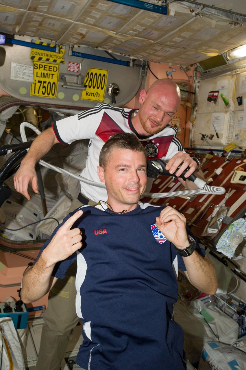 ISS040-E-020383 (26 June 2014) --- European Space Agency astronaut Alexander Gerst, Expedition 40 flight engineer, shaves the head of NASA astronaut Reid Wiseman, flight engineer, in the Unity node of the International Space Station. Gerst used hair clippers fashioned with a vacuum device to garner freshly cut hair. A friendly World Cup Soccer-related agreement between the crew members representing the USA, and Gerst, a German citizen who represents the European Space Agency, called for the American losers of a German-USA match to have their heads shaved. The German team won the match 1-0.