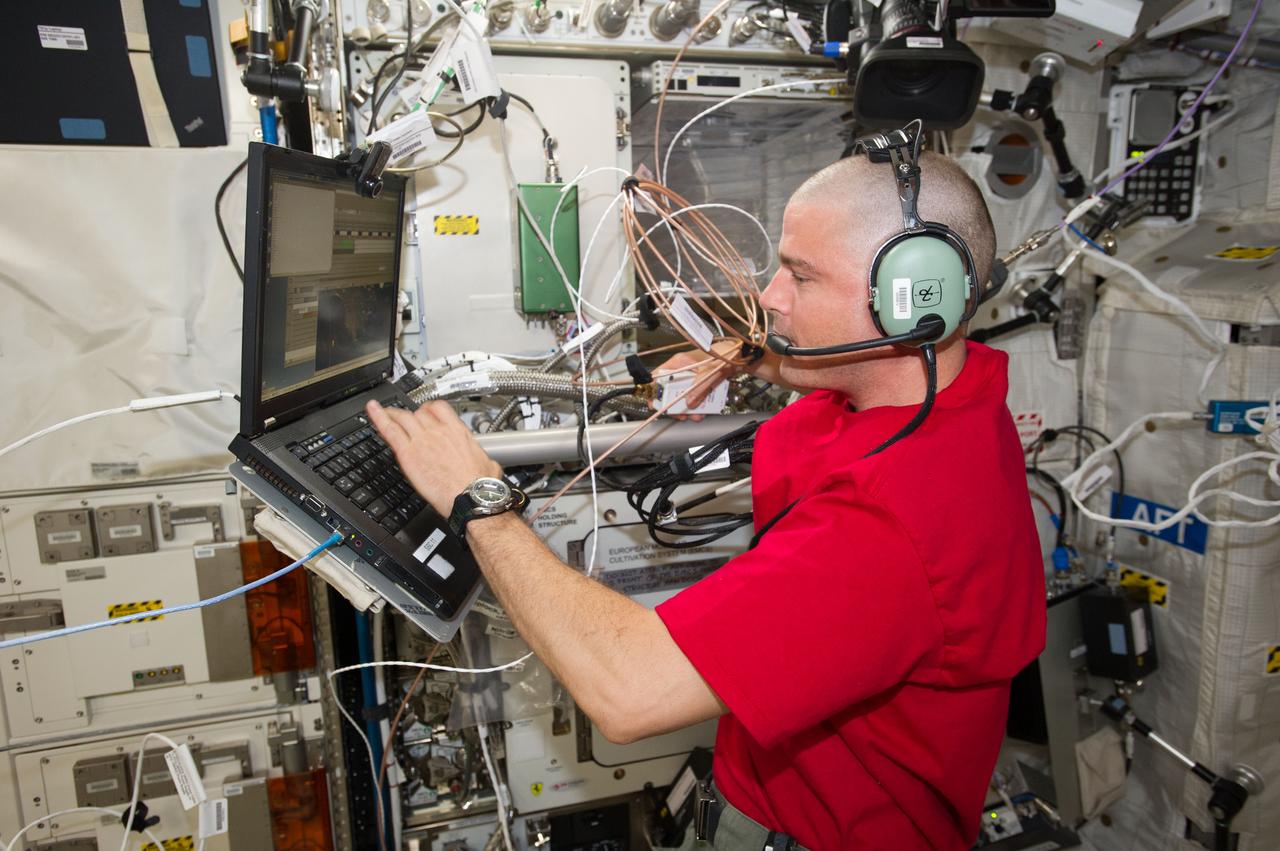 ISS040-E-024110 (28 June 2014) --- NASA astronaut Reid Wiseman, Expedition 40 flight engineer, wearing a communication headset, uses a computer in the Columbus laboratory of the International Space Station.