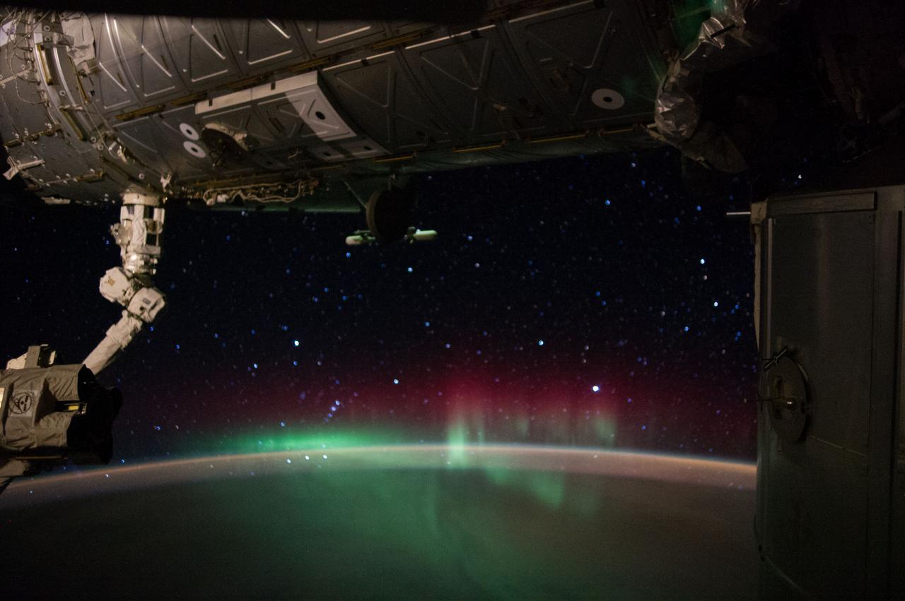 Earth Observation taken during a night pass by the Expedition 40 crew aboard the International Space Station (ISS). Folder lists this as: night, Auroras, long shutters. Part of the Space Station Remote Manipulator System (SSRMS) arm is visible.
