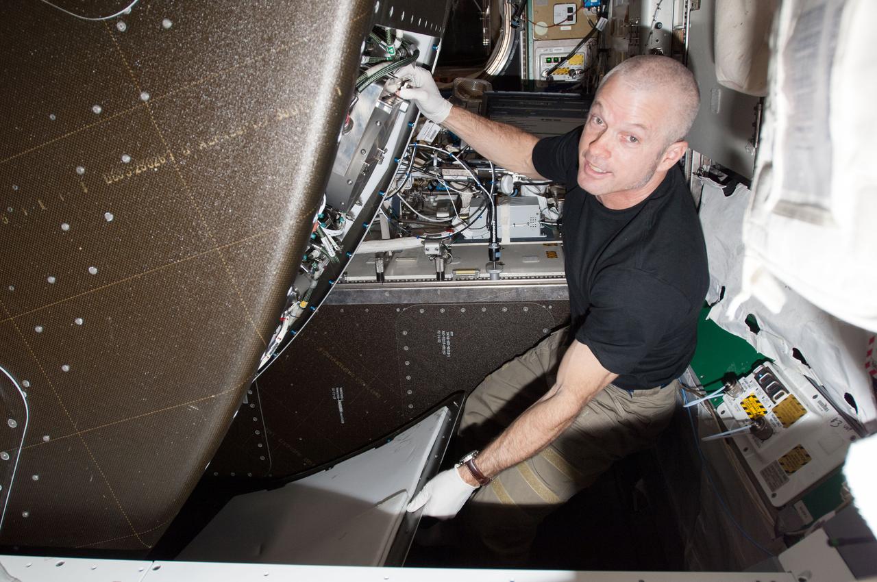 ISS040-E-026307 (1 July 2014) --- NASA astronaut Steve Swanson, Expedition 40 commander, performs in-flight maintenance behind a rack in the Tranquility node of the International Space Station.
