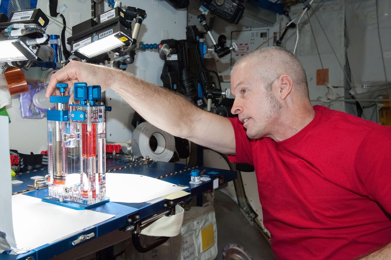 ISS040-E-032827 (3 July 2014) --- NASA astronaut Steve Swanson, Expedition 40 commander, conducts a session with the Capillary Flow Experiment (CFE) in the Harmony node of the International Space Station. CFE is a suite of fluid physics experiments that investigate how fluids move up surfaces in microgravity. The results aim to improve current computer models that are used by designers of low gravity fluid systems and may improve fluid transfer systems for water on future spacecraft.