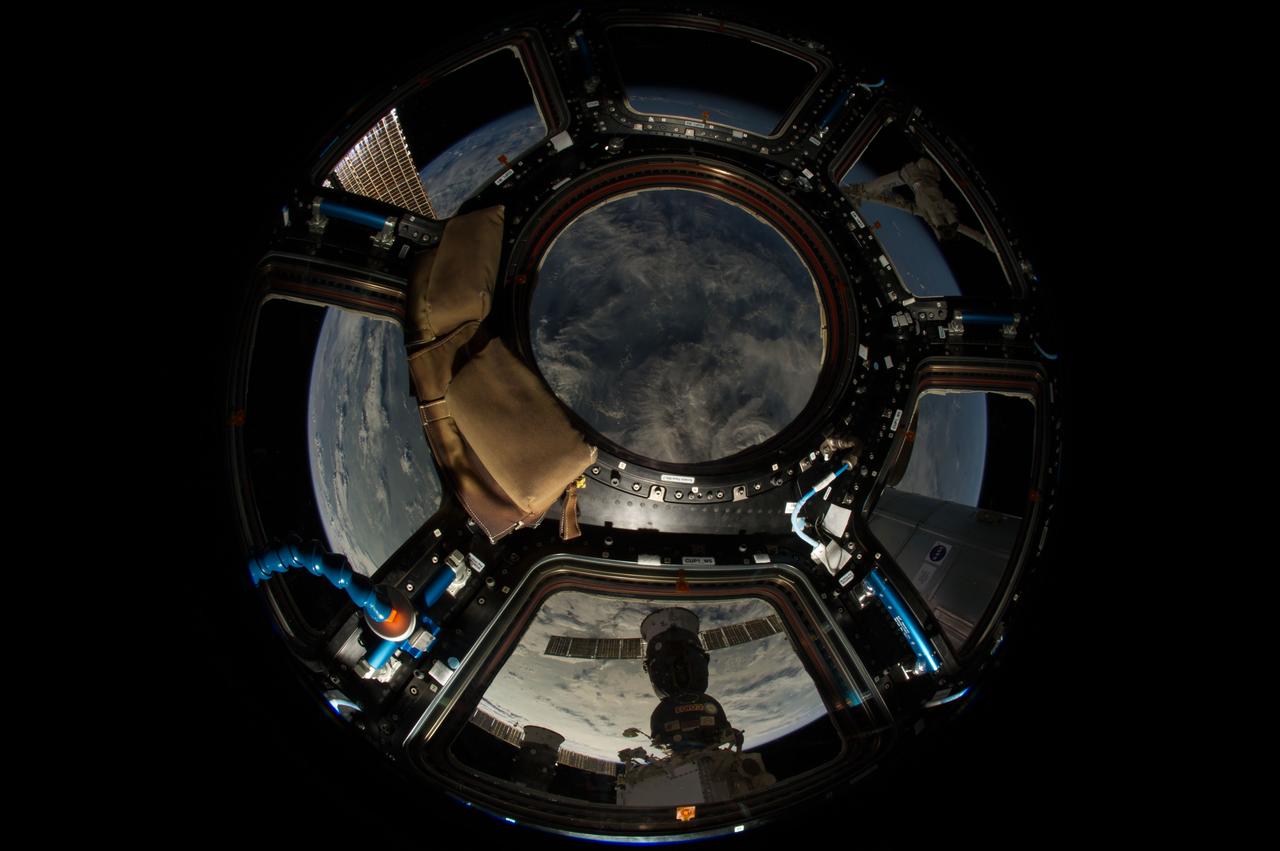 ISS040-E-046846 (6 July 2014) --- One of the Expedition 40 crew members aboard the Earth-orbiting International Space Station recorded this image from inside the Cupola approximately 225 nautical miles above Polynesia. The photo was taken on July 6, 2014 at 15:35:34 GMT. A Russian Soyuz and Russian Progress vehicle can be seen docked to the orbital outpost at bottom center. A blue and white part of Earth provides the backdrop for the scene.