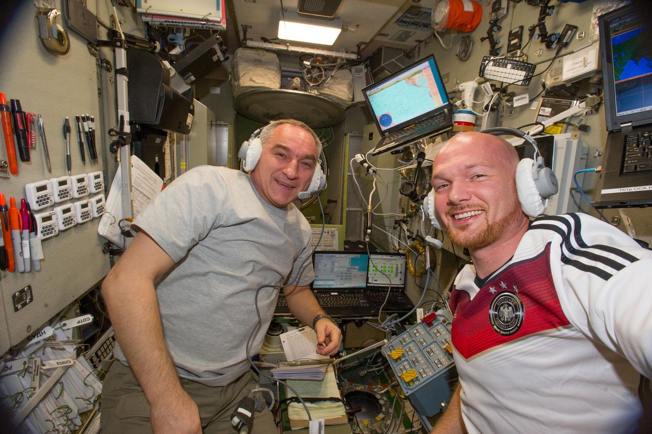 Cosmonaut Alexander Skvortsov and ESA Astronaut Alexander Gerst, Expedition 40 flight engineers, are photographed during ATV equipment preparation in the Service Module (SM) prior to ATV launch.