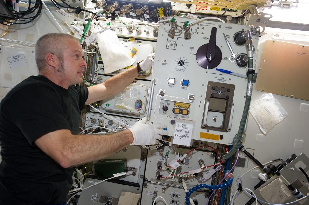 ISS040-E-064628 (15 July 2014) --- NASA astronaut Steve Swanson, Expedition 40 commander, replaces filters in the Potable Water Dispenser (PWD) in the Destiny laboratory of the International Space Station.