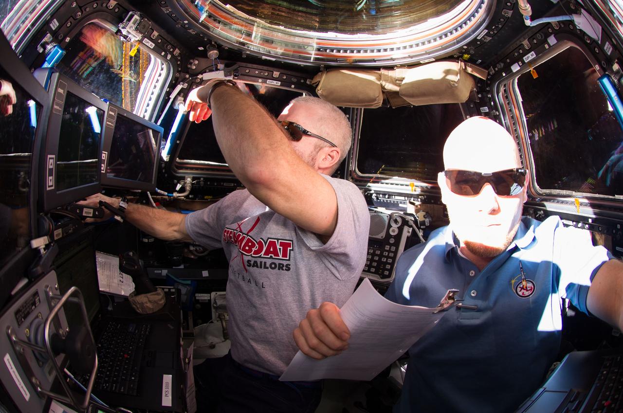 NASA astronaut Steve Swanson (left), Expedition 40 commander; and European Space Agency astronaut Alexander Gerst, flight engineer, are pictured in the International Space Station's Cupola during rendezvous and capture operations of the Orbital Sciences' Cygnus cargo craft.