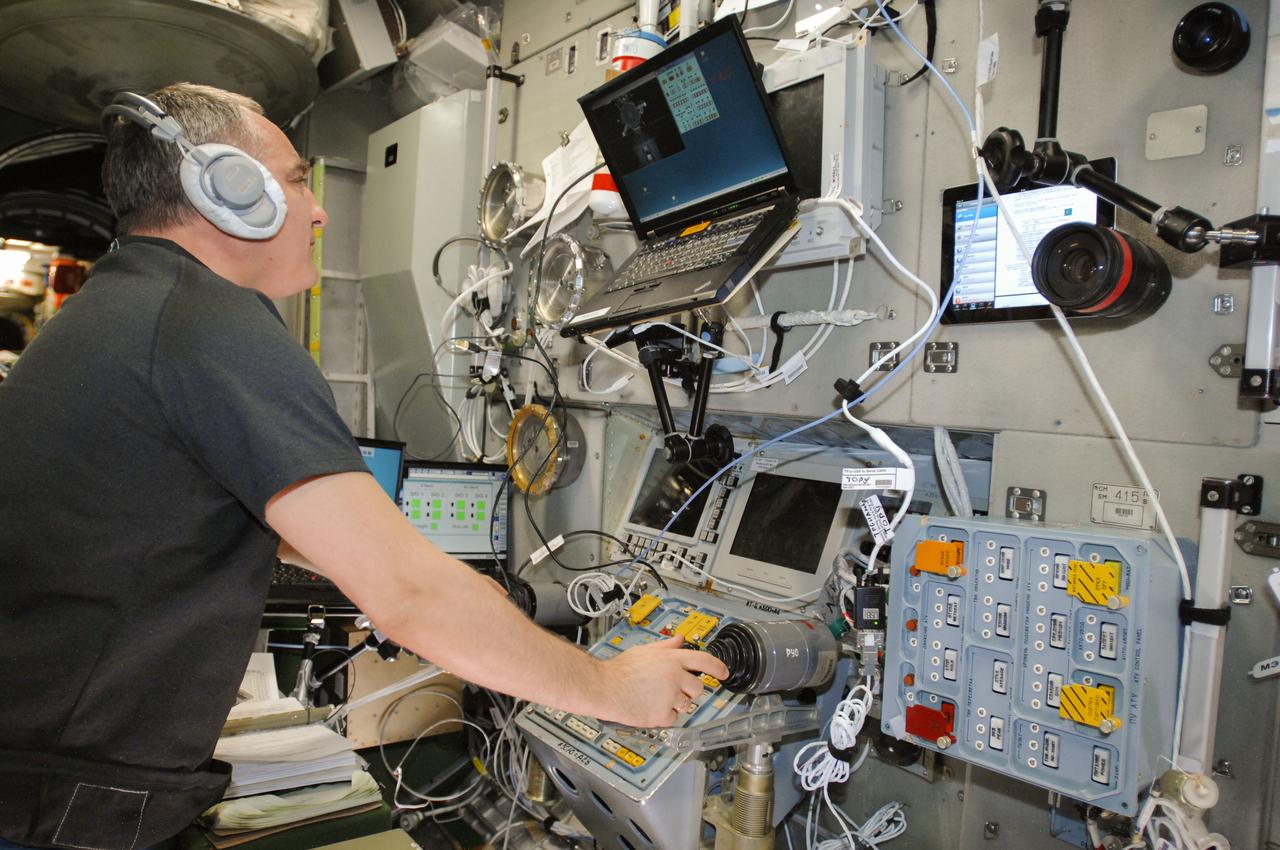 ISS040-E-070859 (22 July 2014) --- Russian cosmonaut Alexander Skvortsov, Expedition 40 flight engineer, practices manual docking techniques with the TORU, or telerobotically operated rendezvous system, in the Zvezda Service Module of the International Space Station in preparation for the docking of the Progress 56 spacecraft. Skvortsov, using the Simvol-TS screen and hand controllers, could manually dock the Progress to the station in the event of a failure of the Kurs automated docking system. The Progress 56 craft is scheduled to complete its automated docking to the Pirs docking compartment at 11:30 p.m. (EDT) on July 23, 2014.
