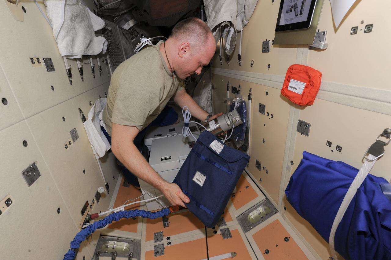 Photographic documentation of Cosmonaut Oleg Artemyev, Expedition 40 flight engineer, working on the Hardware Transfer from Ð¢ÐÐ 423 (DC1) for CASKAD experiment. Photo taken by the Expedition 40 crew.