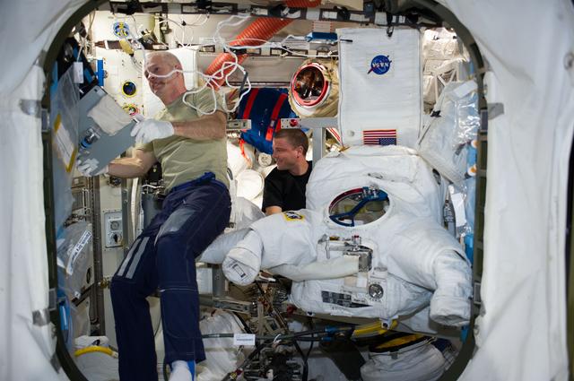 NASA image: Swanson and Wiseman in Airlock with EMU