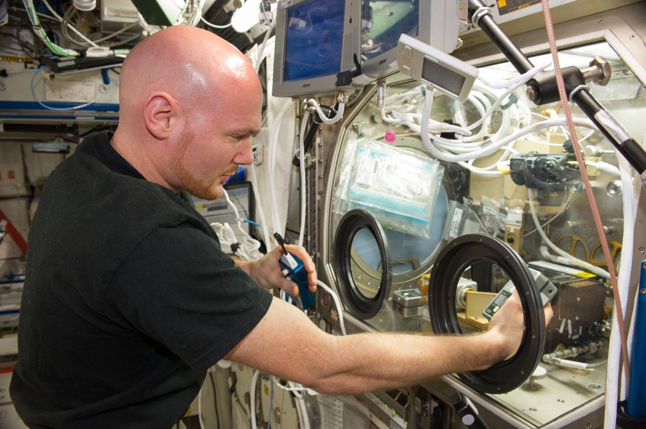 ISS040-E-083578 (30 July 2014) --- European Space Agency astronaut Alexander Gerst, Expedition 40 flight engineer, performs two tests with a combustion experiment known as the Burning and Suppression of Solids (BASS-II) in the Microgravity Science Glovebox (MSG) in the Destiny laboratory of the International Space Station. The experiment seeks to provide insight on how flames burn in space compared to Earth which may provide fire safety benefits aboard future spacecraft.
