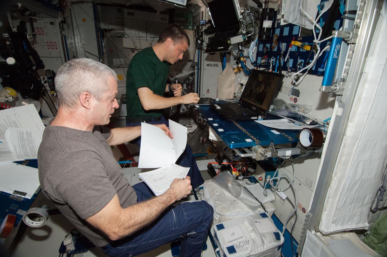 ISS040-E-088730 (4 Aug. 2014) --- In the International Space Station?s Harmony node, NASA astronauts Steve Swanson (foreground), Expedition 40 commander; and Reid Wiseman, flight engineer, perform a portable onboard computer Dynamic Onboard Ubiquitous Graphics (DOUG) software review in preparation for two upcoming U.S. spacewalks.