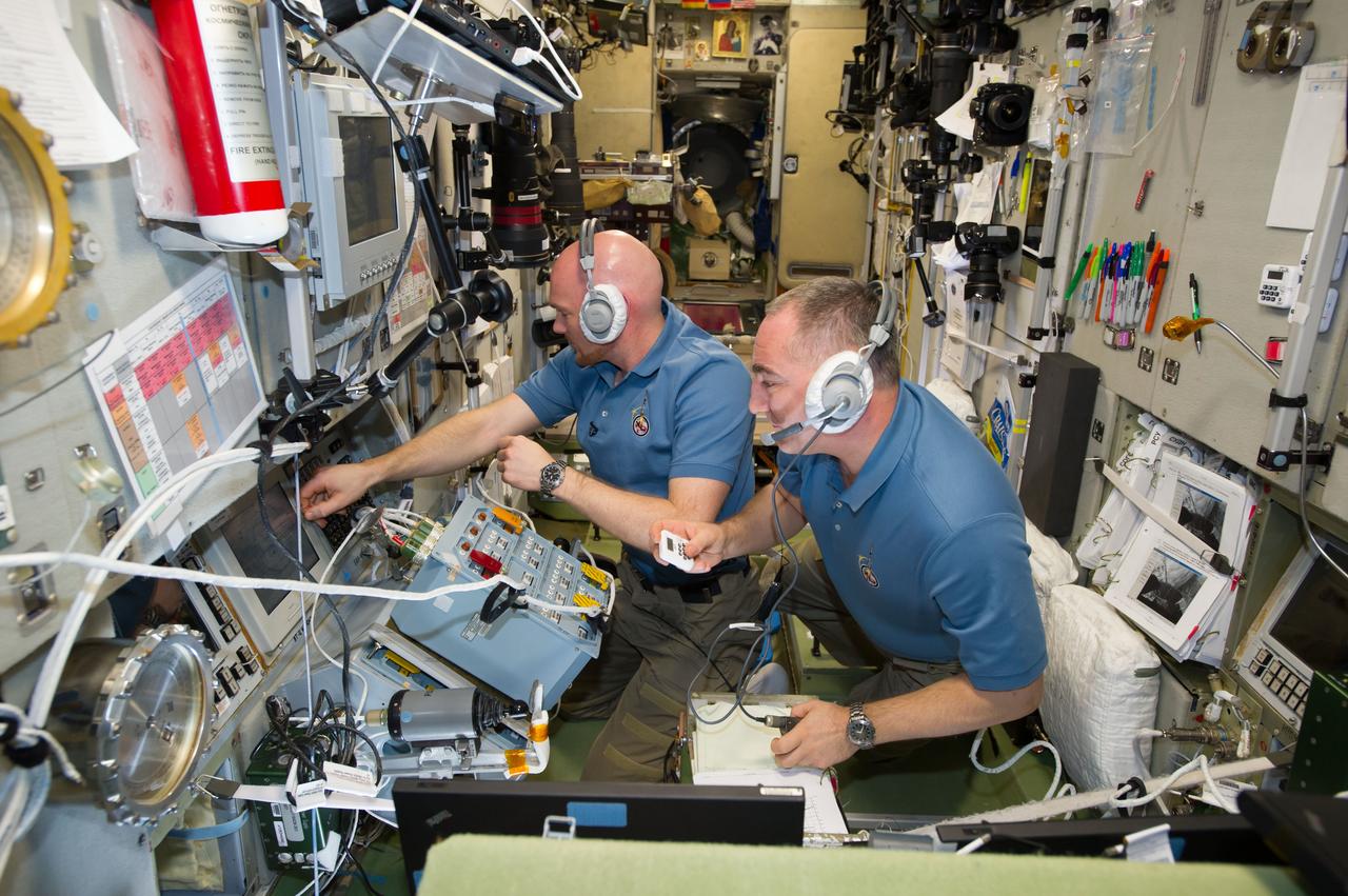ISS040-E-091634 (12 Aug. 2014) --- In the Zvezda Service Module, European Space Agency astronaut Alexander Gerst (left) and Russian cosmonaut Alexander Skvortsov, both Expedition 40 flight engineers, monitor the approach and docking of ESA's "Georges Lemaitre" Automated Transfer Vehicle-5 (ATV-5) to the International Space Station.