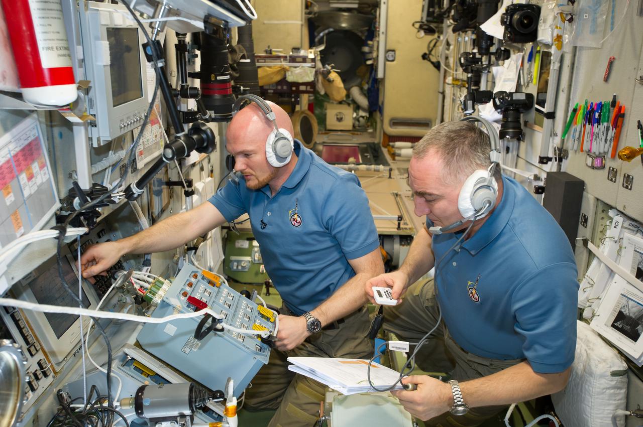 ISS040-E-091635 (12 Aug. 2014) --- In the Zvezda Service Module, European Space Agency astronaut Alexander Gerst (left) and Russian cosmonaut Alexander Skvortsov, both Expedition 40 flight engineers, monitor the approach and docking of ESA's "Georges Lemaitre" Automated Transfer Vehicle-5 (ATV-5) to the International Space Station.
