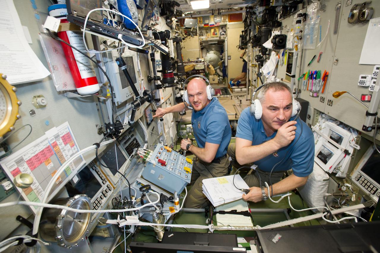 ISS040-E-091688 (12 Aug. 2014) --- In the Zvezda Service Module, European Space Agency astronaut Alexander Gerst (left) and Russian cosmonaut Alexander Skvortsov, both Expedition 40 flight engineers, monitor the approach and docking of ESA?s "Georges Lemaitre" Automated Transfer Vehicle-5 (ATV-5) to the International Space Station.